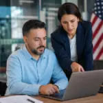 man in wheelchair and woman reviewing disability veteran outreach posting requirements on a laptop.